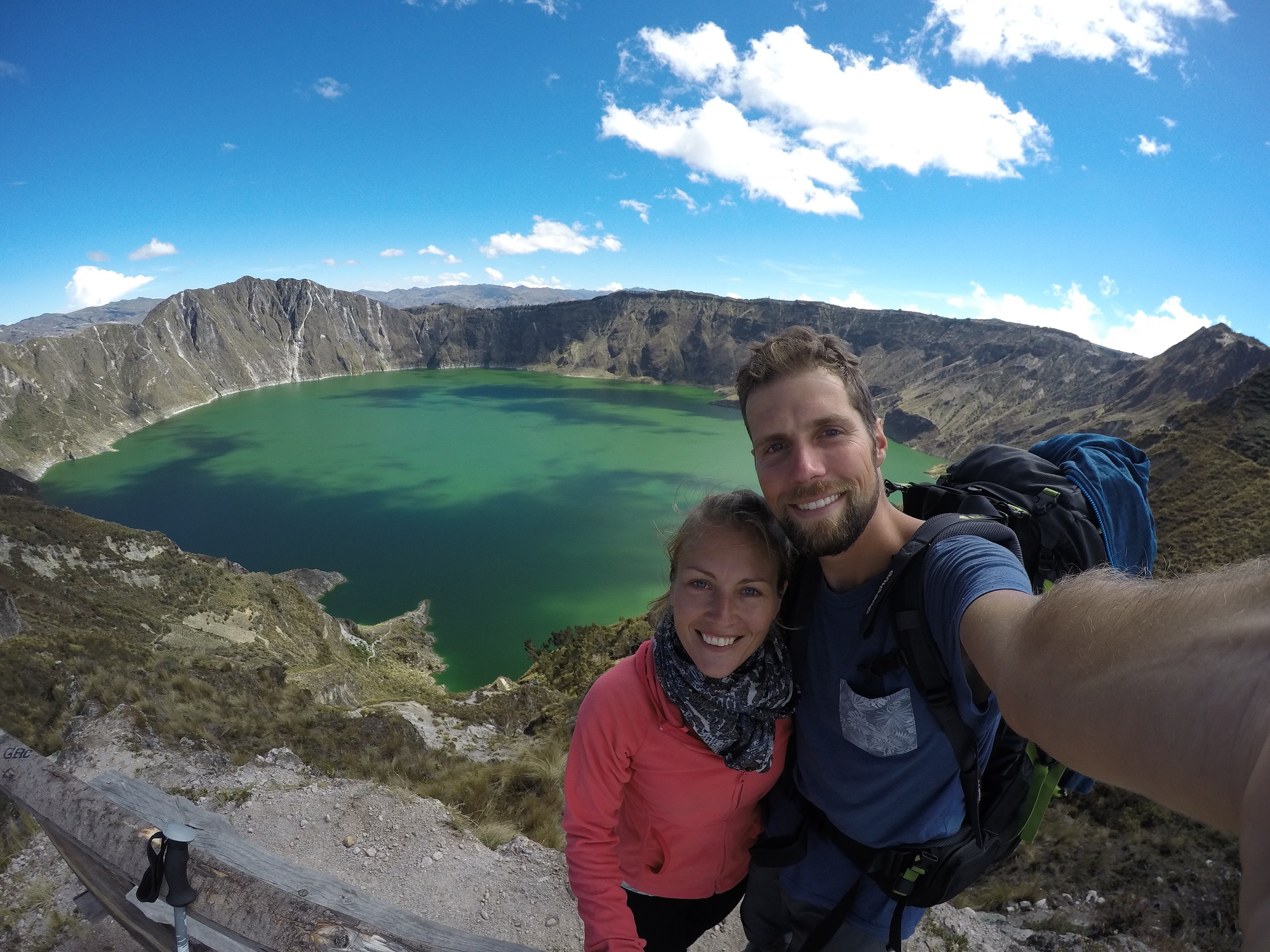 Couple hikers on the rim of Quilotoa crater