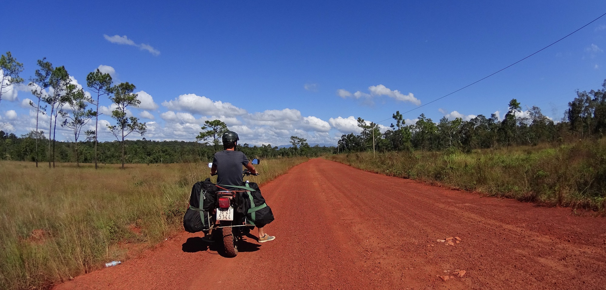 Motorcycle on red dirt roads towards Cardamom mountains